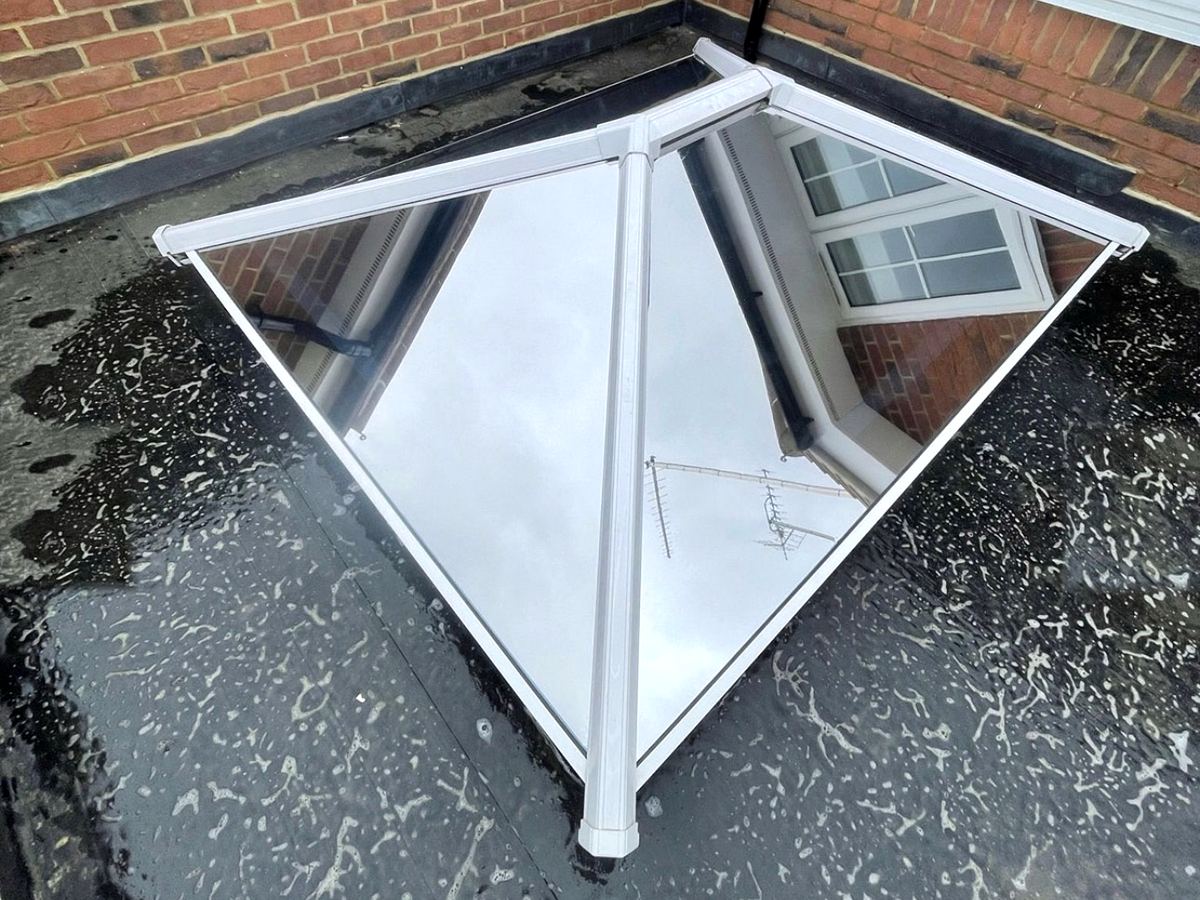 Solar film on a small white-framed roof lantern, the glass reflecting the house